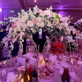 Large pastel floral centerpiece over a banquet table at an event