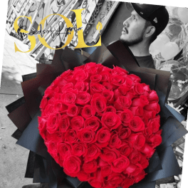 Large bouquet of red roses wrapped in black paper