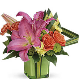 Pink lilies and orange roses in a green glass vase