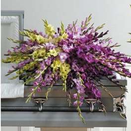 Purple and green floral spray on a casket