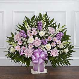 Lavender and white floral spray with a purple ribbon bow