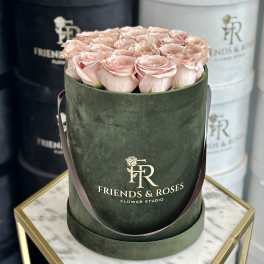 Pink roses arranged in a dark green hat box