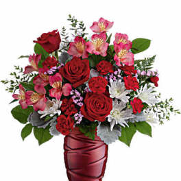 Red and pink mixed bouquet in a burgundy vase