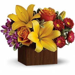 Yellow lilies and orange roses in a wooden cube vase
