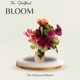 Mixed bouquet in a beige vase with pink and peach blooms