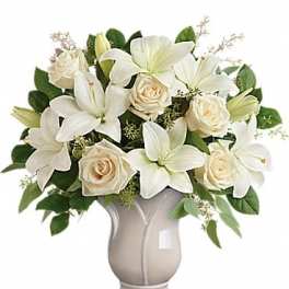 White lilies and cream roses arranged in a silver vase