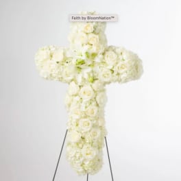 White floral cross arrangement on a stand