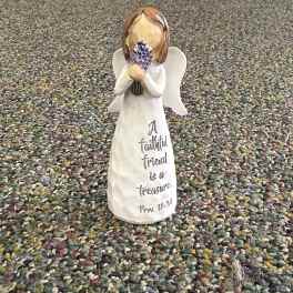 Small angel figurine holding purple flowers