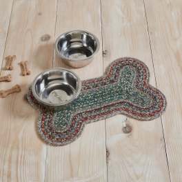 Two stainless steel pet bowls on a braided bone-shaped mat with dog treats.