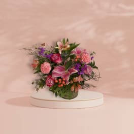 Pink and purple mixed flower arrangement in a glass vase