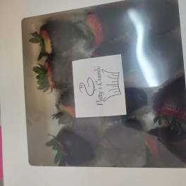 Box of chocolate-dipped strawberries with pink and white decoration