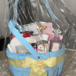 Gift basket with bath and body items wrapped in clear plastic and ribbon