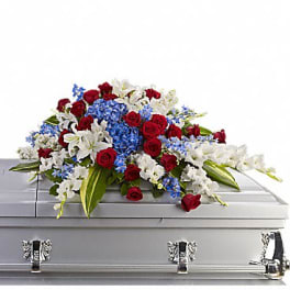 Red, white, and blue flowers arranged on a silver casket