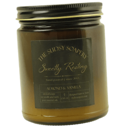 Amber jar candle with a black lid and label