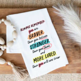 White printed sympathy card on a wooden surface with bead garland