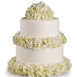 Three-tier white cake decorated with pale cream flowers