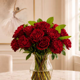 Red roses and carnations in a clear glass vase