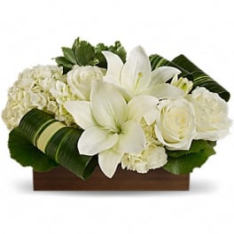 White lilies and roses arranged in a wooden box