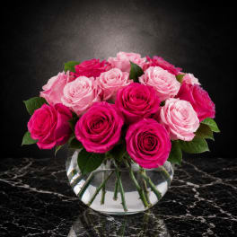 Pink and hot pink roses arranged in a clear glass vase