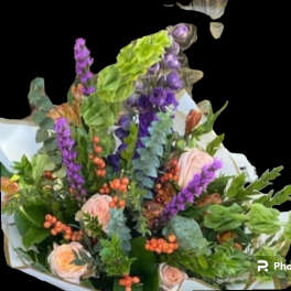 Bouquet of pink roses and purple flowers with orange berries