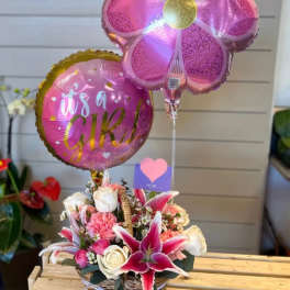 Pink balloon over a basket of pink and white flowers