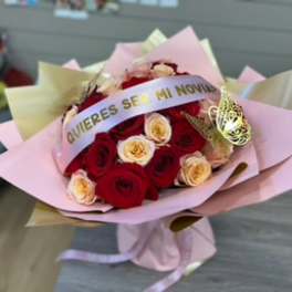 Bouquet of red and cream roses wrapped in pink paper