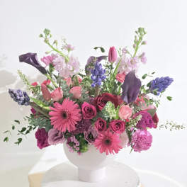 Pink and purple mixed bouquet in a white vase