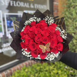 Bouquet of red roses with baby's breath in black wrap