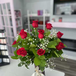 Red roses arranged in a vase with baby's breath