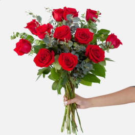 Handheld bouquet of red roses with eucalyptus and greenery