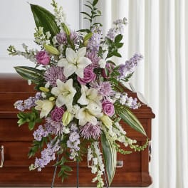 Standing floral spray with white lilies, pink roses, and lavender flowers