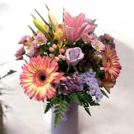 Mixed bouquet in a lavender vase with pink and purple flowers