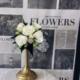 White rose bouquet on a gold pedestal stand