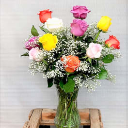Mixed roses in a clear glass vase with baby's breath.