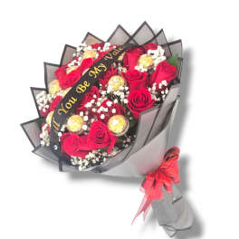 Bouquet of red roses with gold-wrapped chocolates and a ribbon