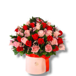 Bouquet of red and pink roses in a pink hatbox with a red ribbon