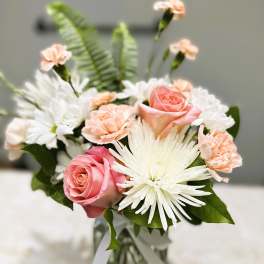 Pink roses and white daisies in a glass vase