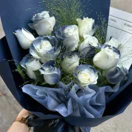 Bouquet of white roses wrapped in dark blue paper
