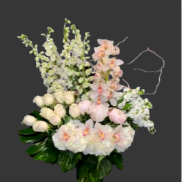 Tall bouquet of white and pale pink flowers in a glass vase