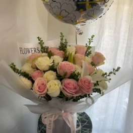 Bouquet of pink and white roses wrapped in white paper