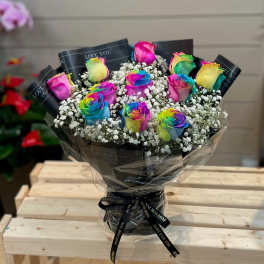 Bouquet of rainbow-colored roses with baby's breath in black wrapping