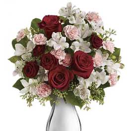 Bouquet of red roses, white lilies, and pink carnations in a glass vase
