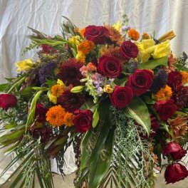 Large mixed bouquet of red roses, yellow blooms, and orange flowers