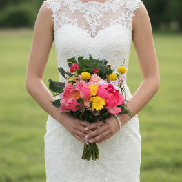 Bride holding a colorful bouquet of pink and yellow flowers