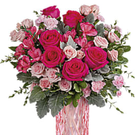 Pink and blush rose bouquet in a pink glass vase