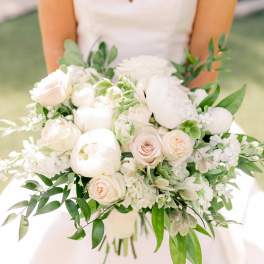 Bride holding a white and blush bouquet with greenery
