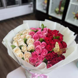 Bouquet of pink, red, and cream roses in white wrapping
