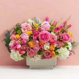 Pink and yellow mixed flower arrangement in a rectangular vase
