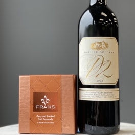Wine bottle beside a box of gray and smoked salt caramels