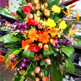 Large tropical floral spray with orange, pink, purple, and yellow blooms